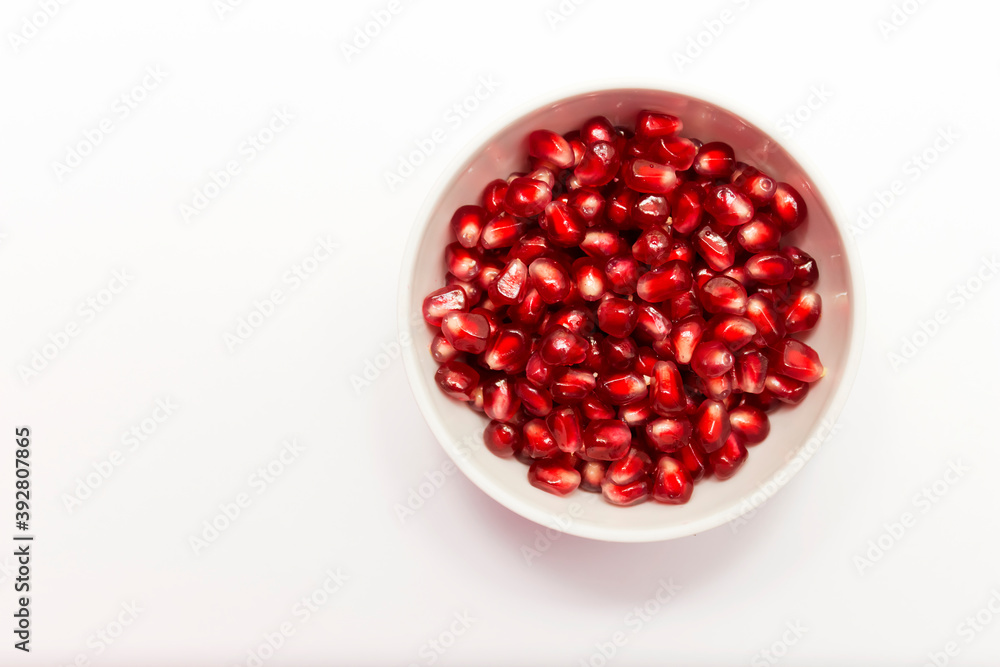 Pomegranate seeds in a Cup on a white background. Pomegranate as a protection against coronavirus in the perion pandemic.