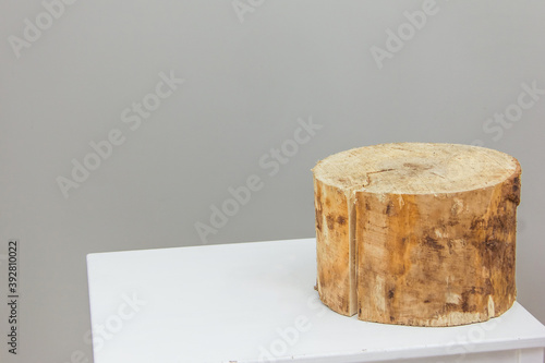 Wooden display pedestal or product showcase on a gray background with a cylinder stand