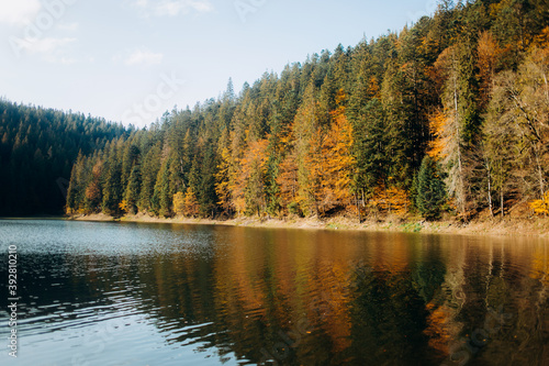 Amazing autumn landscape. Reflection of colored trees in the lake