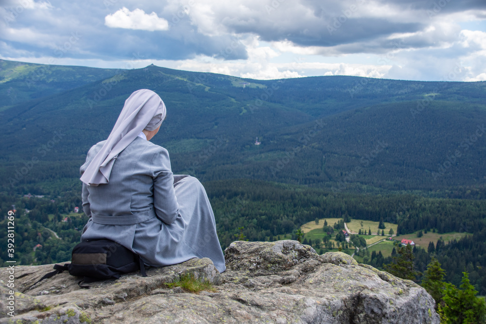 Fototapeta premium Nun reads the bibles in the mountains - Christian contemplation