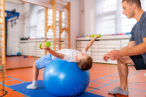 Slika na platnu Pectoral or chest muscle exercises for children with a fitness ball