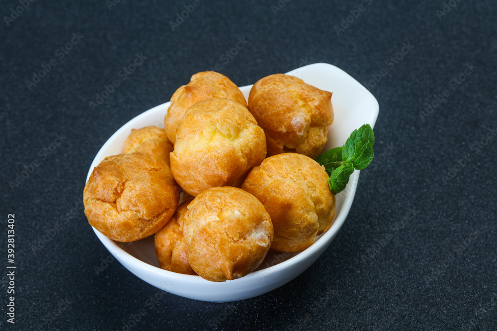 Sweet tasty profiteroles heap in the bowl Sweet tasty profiteroles heap in the bowl