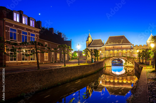 Old city gate Koppelpoort in Amersfoort city, the Netherlands during sunset. Two towers are connected to an arch gate. photo