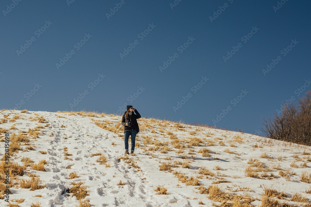 The pretty girl looking on the beautiful view at the mountain in the sunny day. Blue sky with copy space.
