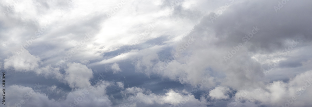 Panorama of the sky with gray rain clouds, through which sunlight barely penetrates Panorama of the sky with gray rain clouds, through which sunlight barely penetrates