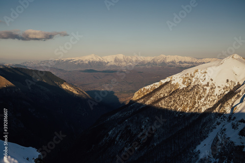 Panorama of valley. Snow-capped top of mountains. Mountain landscape in Italy.