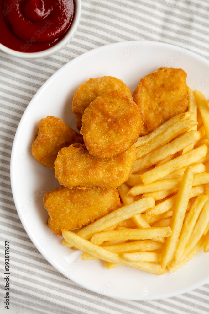 Tasty Fastfood: Chicken Nuggets and French Fries on a plate on cloth, top view. Flat lay, overhead, from above. Close-up. Tasty Fastfood: Chicken Nuggets and French Fries on a plate on cloth, top view. Flat lay, overhead, from above. Close-up.