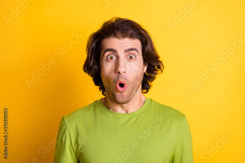 Photo of young attractive multiethnic guy amazed surprised shocked news information discount isolated over yellow color background