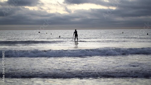 Female SUP surfer in the evening photo