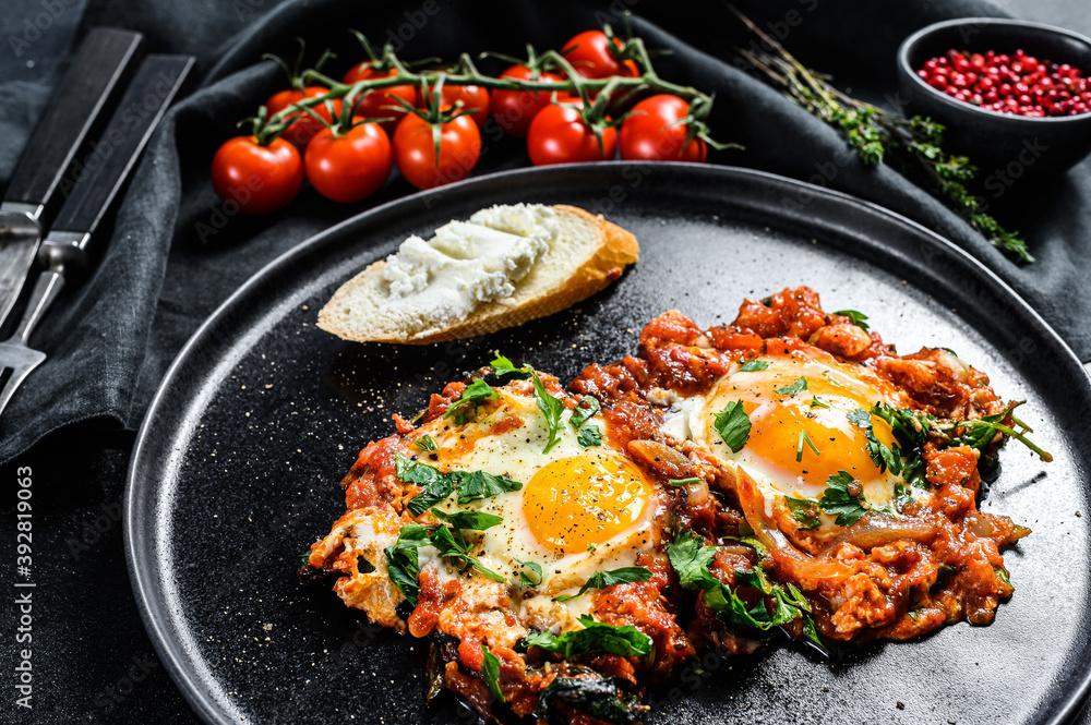 Traditional Israeli Cuisine dishes Shakshuka. Fried egg with tomatoes and paprika.  Black background. Top view