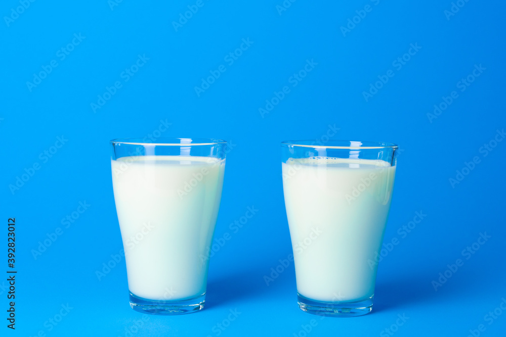 Glass jar with fresh milk against blue background Glass jar with fresh milk against blue background