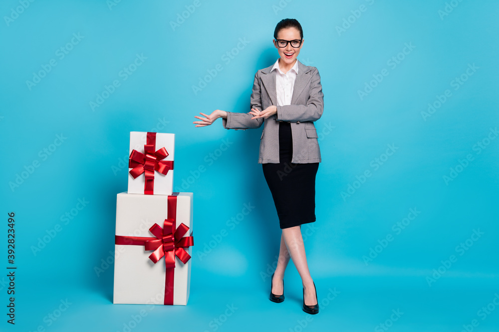 Full size photo chief girl prepare pile stack gift box hold hand wear skirt blazer jacket isolated blue color background Full size photo chief girl prepare pile stack gift box hold hand wear skirt blazer jacket isolated blue color background