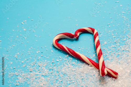 Two candy canes making a heart on a blue background, Christmas candy cane heart