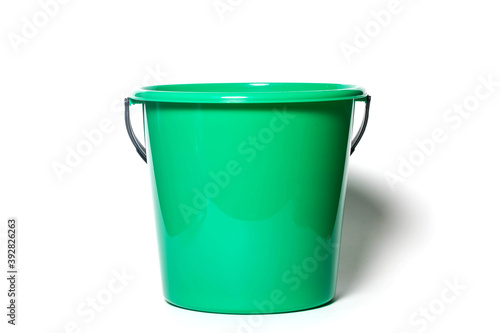 Bright green round plastic kitchen bucket for water or garbage isolated on white background. Close-up container for home cleaning. Concept of kitchen home accessories for site. Copy space