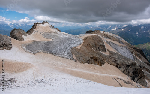 Glacier Tetnuldi located in Caucasus mountains in Svaneti Georgia. The glaciated slopes of the mount Tetnuldi with a lot of crevasses. Gloomy sky with low clouds. photo