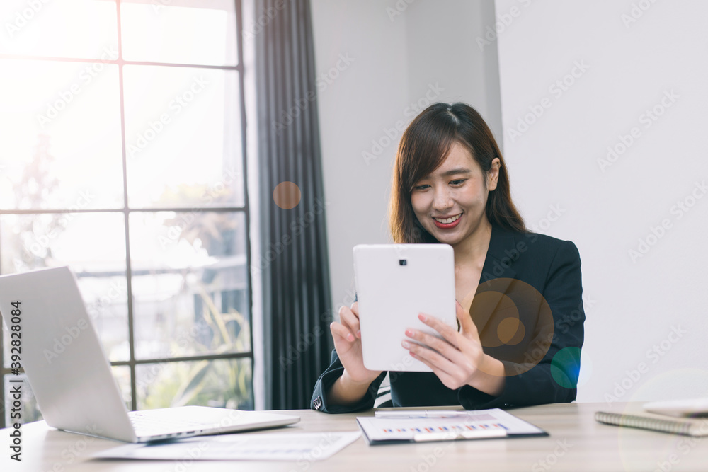 An Asian woman is wearing headphones and playing a tablet to communicate, listen to lectures, study online or chat with her friends. An Asian woman is wearing headphones and playing a tablet to communicate, listen to lectures, study online or chat with her friends.