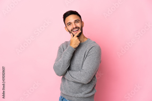 Young caucasian man isolated on pink background happy and smiling