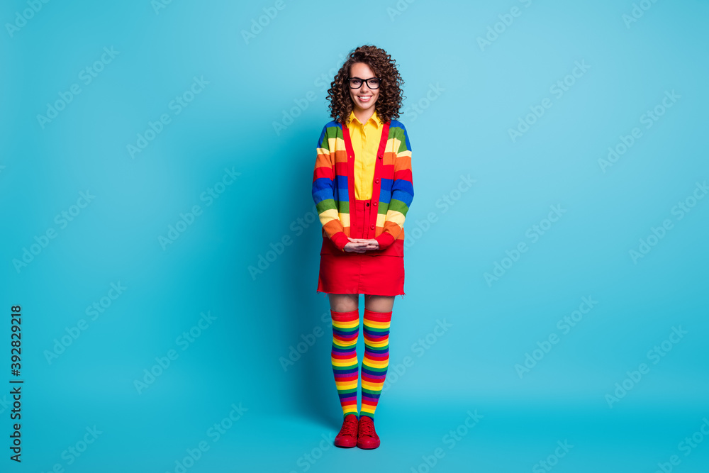 Full length body size view of lovely shy cheerful wavy-haired girl posing wear striped apparel isolated on bright blue color background Full length body size view of lovely shy cheerful wavy-haired girl posing wear striped apparel isolated on bright blue color background