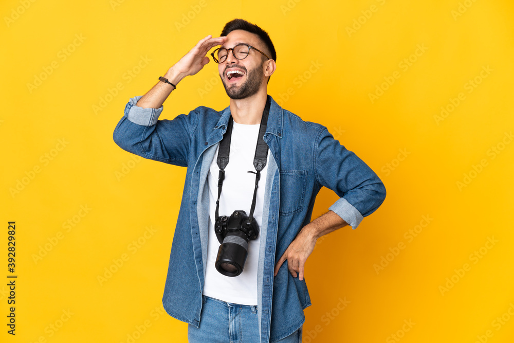 Young photographer girl isolated on yellow background smiling a lot Young photographer girl isolated on yellow background smiling a lot