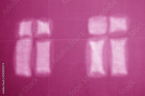 Reflection of two windows on pink cement wall.