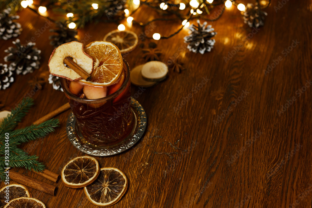 High angle tasty mulled wine placed on wooden table with glowing garland for Christmas celebration High angle tasty mulled wine placed on wooden table with glowing garland for Christmas celebration