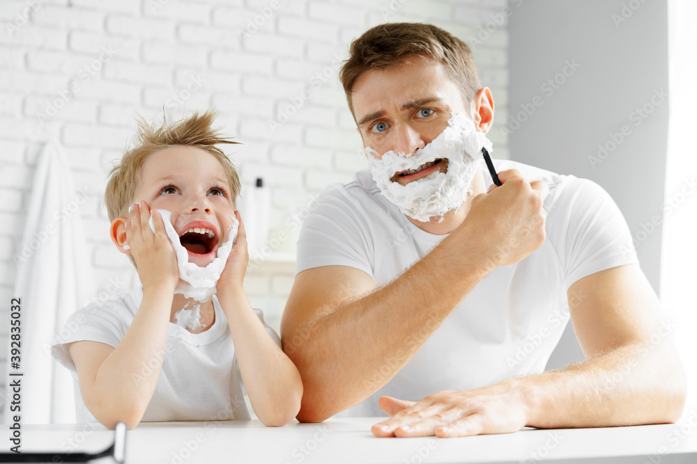 Father and little son having fun with shaving foam