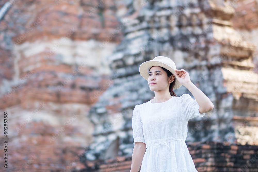 Tourist Woman in white dress visiting to ancient stupa in Wat Chaiwatthanaram temple in Ayutthaya Historical Park, summer, Asia and Thailand travel concept