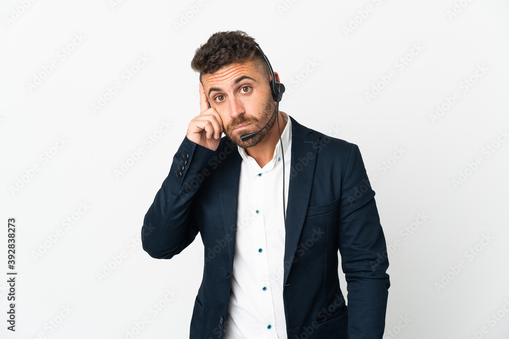 Telemarketer man working with a headset isolated on white background thinking an idea Telemarketer man working with a headset isolated on white background thinking an idea