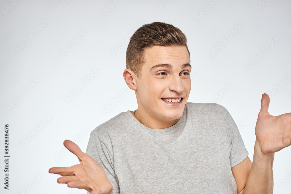 Cheerful emotional man gray t-shirt gesturing with hands studio lifestyle Cheerful emotional man gray t-shirt gesturing with hands studio lifestyle