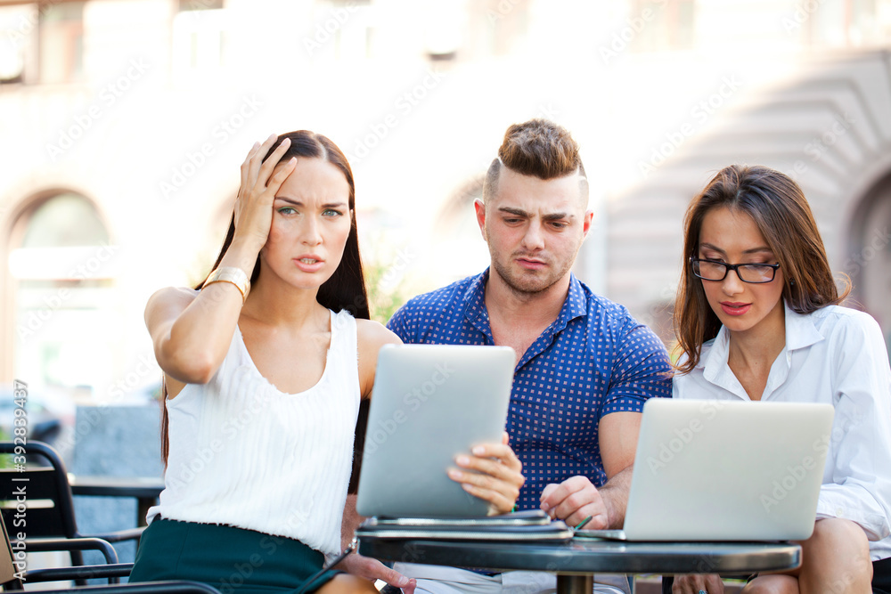 Interracial business team working at laptop in a office outdoor Interracial business team working at laptop in a office outdoor