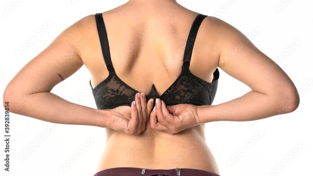 a rear view of a woman taking off her bra on a white background a rear view of a woman taking off her bra on a white background