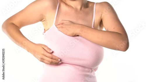 big breasted woman adjusting her breasts under the shirt on white background