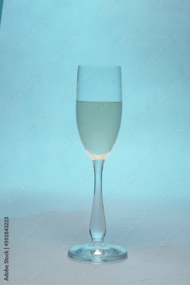 glas with white wine on blue backround glas with white wine on blue backround