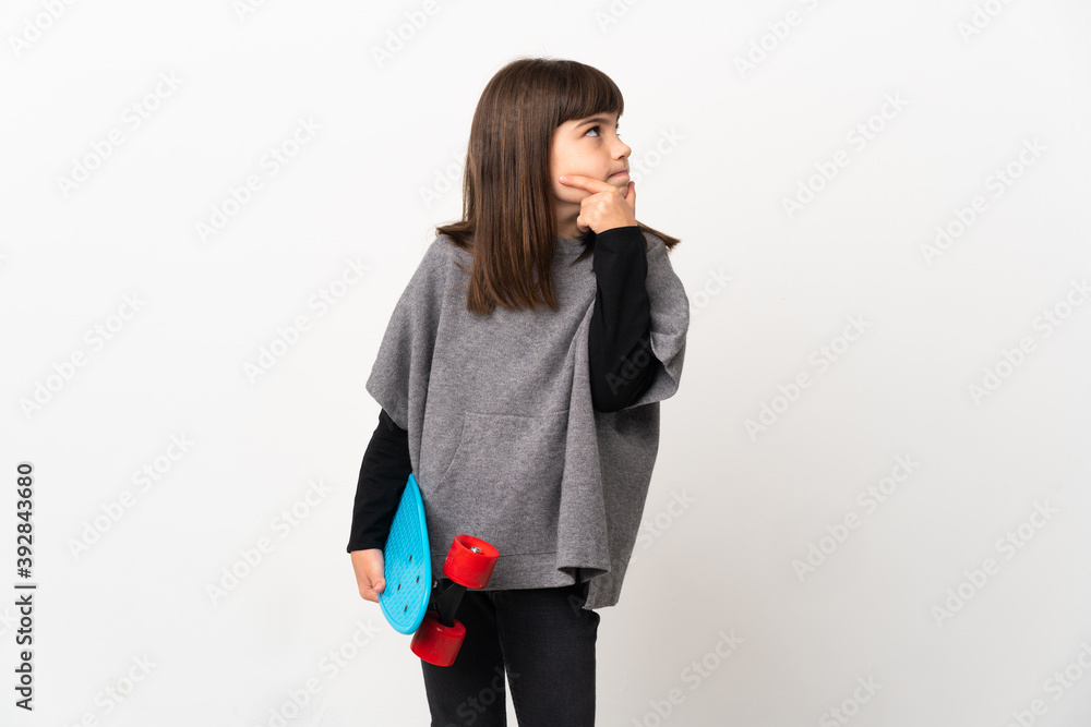 Little girl isolated on white background with a skate and looking lateral Little girl isolated on white background with a skate and looking lateral
