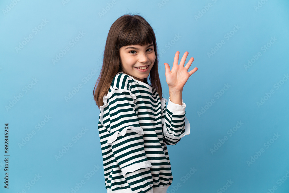 Fototapeta premium Little girl over isolated background saluting with hand with happy expression