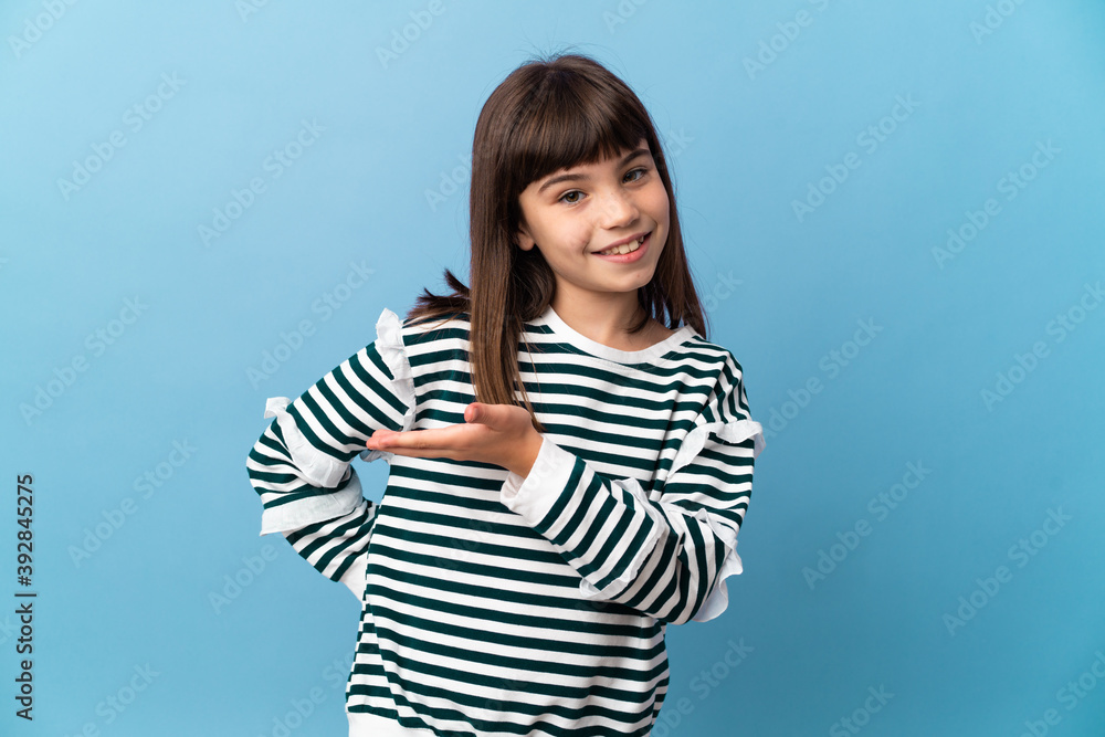 Little girl over isolated background presenting an idea while looking smiling towards Little girl over isolated background presenting an idea while looking smiling towards