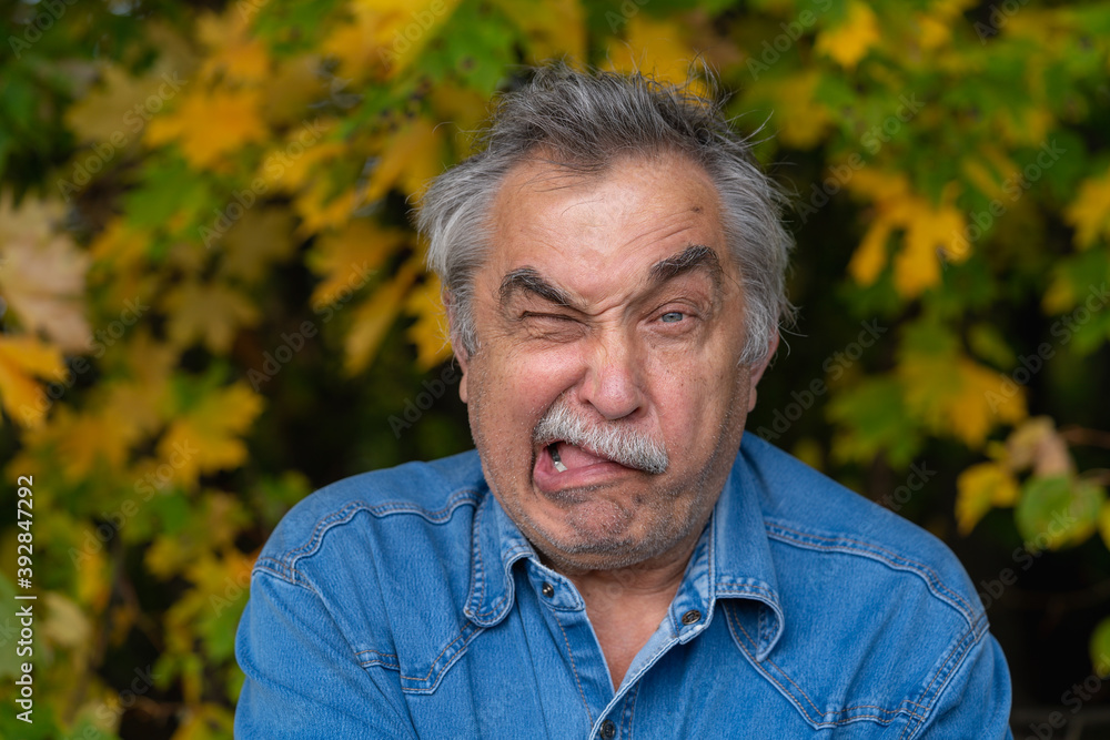 Portrait of 70-year-old elderly man, gesturing funny and comical, his expression looks cheerful. Portrait of 70-year-old elderly man, gesturing funny and comical, his expression looks cheerful.