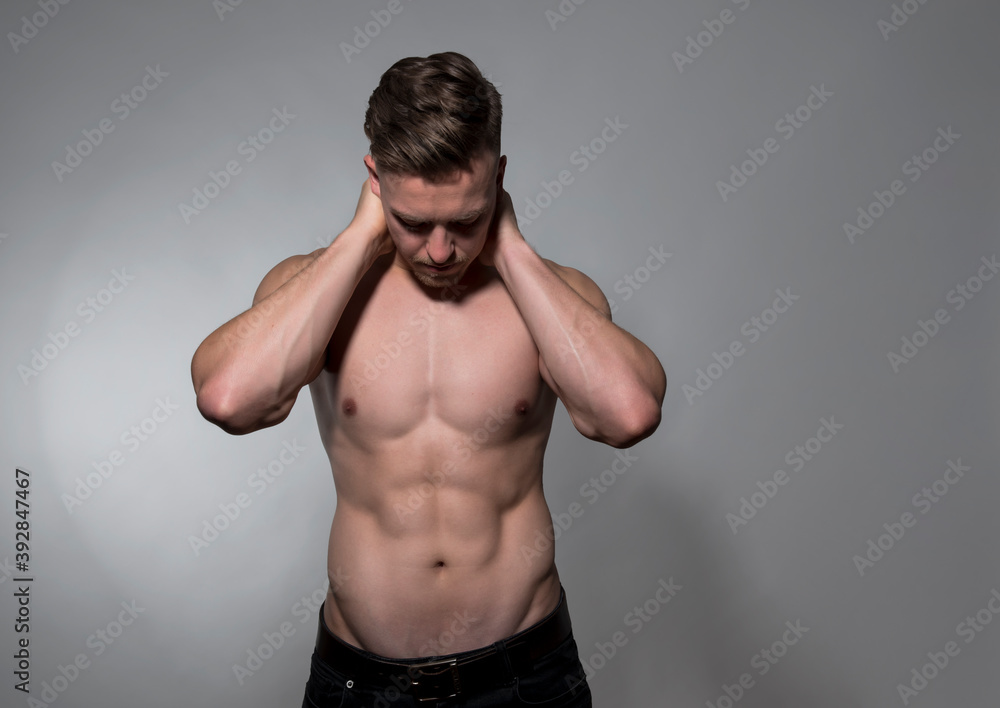 Fototapeta premium Muscular and fit bodybuilder shirtless on grey background