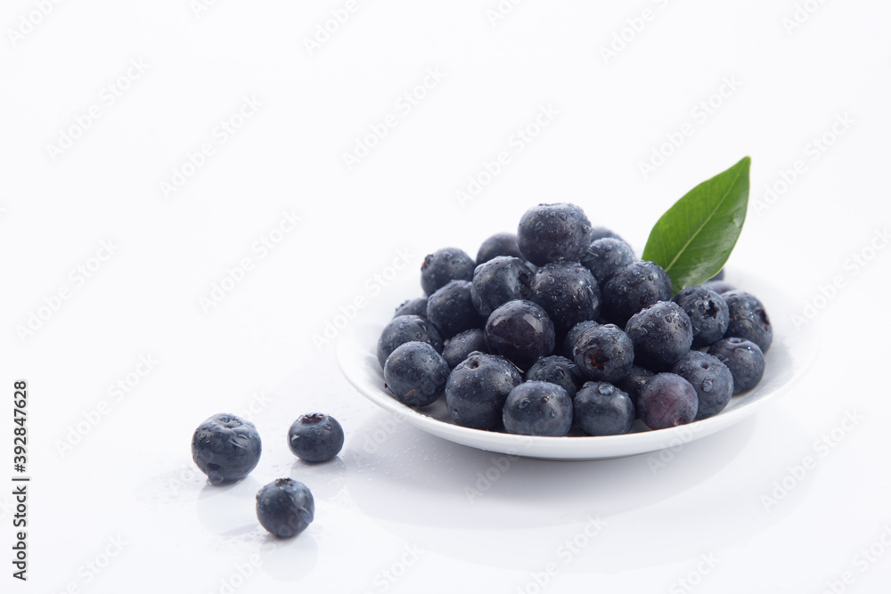 Dish with a bunch of blueberries isolated on white background. Dish with a bunch of blueberries isolated on white background.