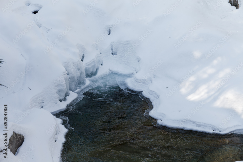 Warren falls - frozen creek under ice and snow with rocky shores. Sunny winter day Warren falls - frozen creek under ice and snow with rocky shores. Sunny winter day