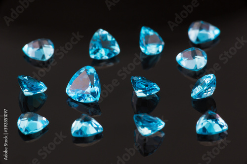 gorgeous blue topaz stones scattered on a mirror glass