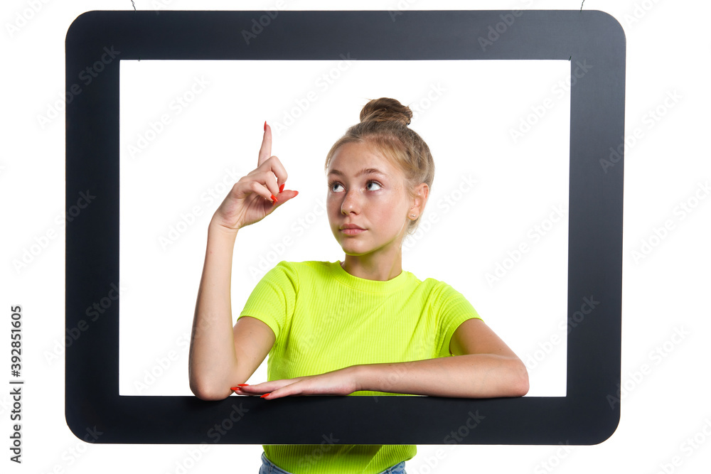 Teen girl looking through digital tablet frame pointing finger up Teen girl looking through digital tablet frame pointing finger up