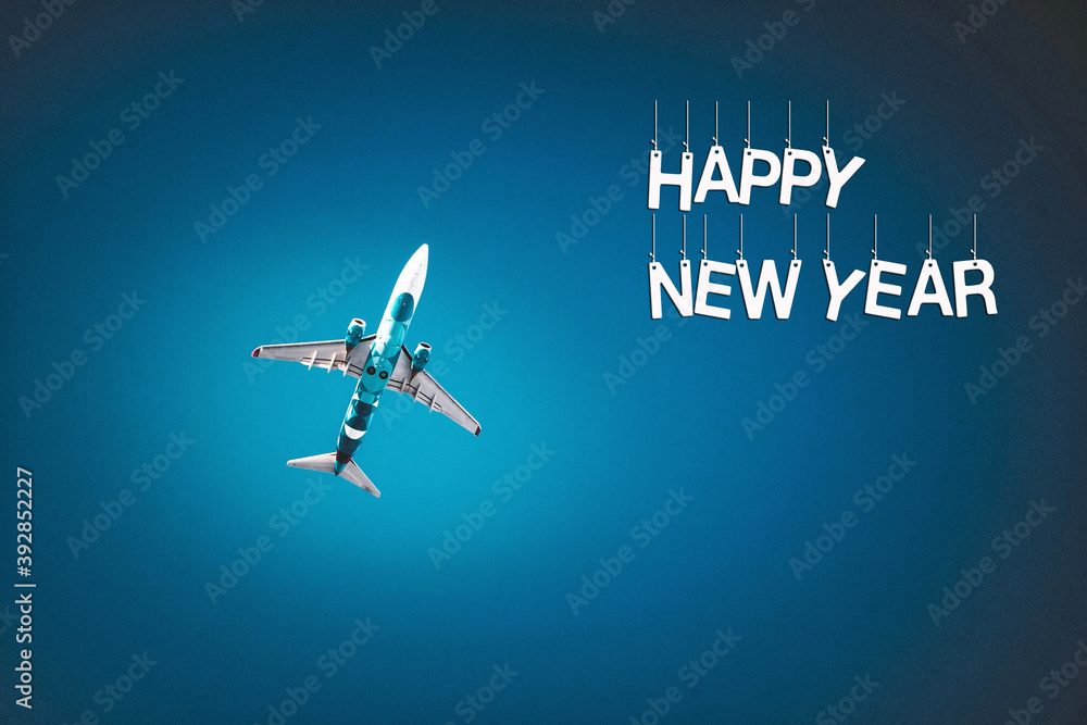 The airplane flies on a dark blue background with the inscription Happy new year.