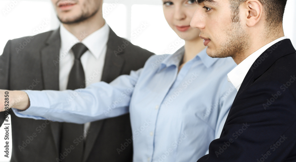 Group of business people discussing questions at meeting in office. Colleagues working with computer at workplace Group of business people discussing questions at meeting in office. Colleagues working with computer at workplace