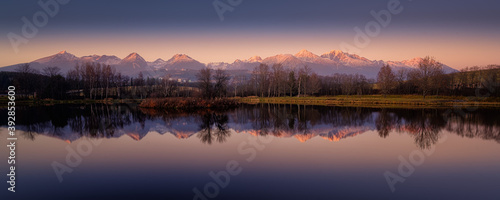 Fototapeta Naklejka Na Ścianę i Meble -  autumn pond with the reflection of the mountains on the surface at sunset