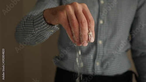 Baker pours flour on the table
