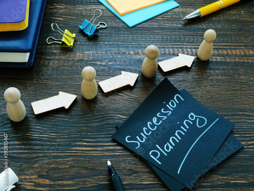 Succession planning sign and figurines with arrows. photo