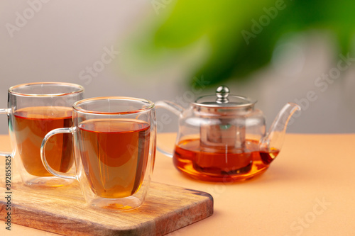 Glass teapot and two glass cups with tea