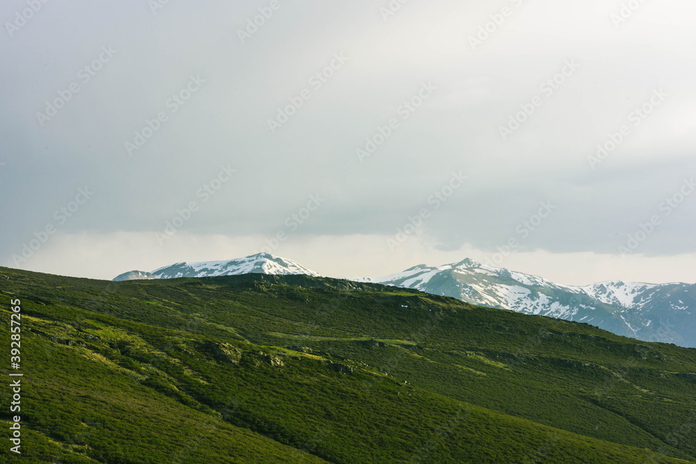 landscape with clouds snowy mountains ang green valley