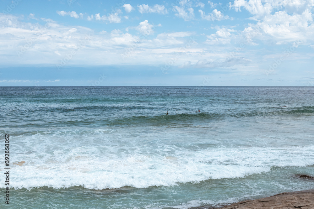 Surfers take on waves at the beach